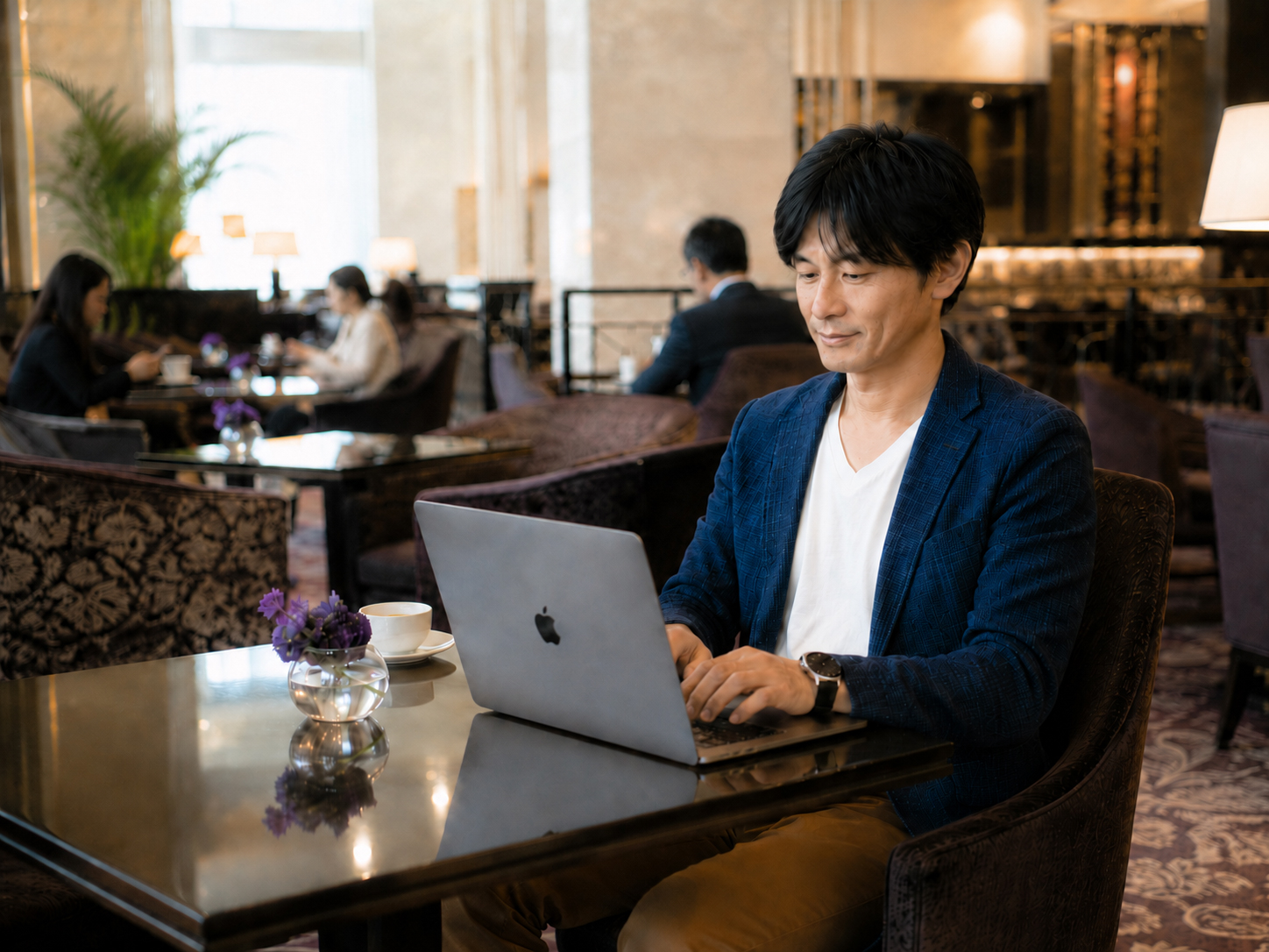 ホテルラウンジでパソコンに向かい仕事をする関達也